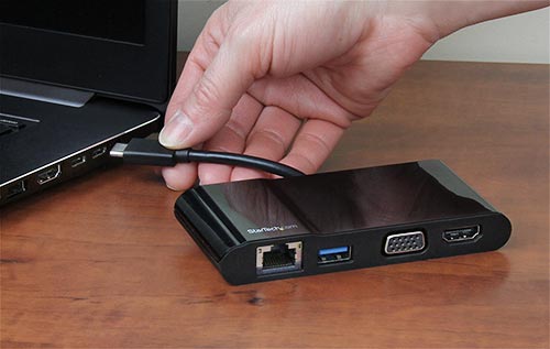 Photo showing the multiport adapter being connected to the USB-C port on a laptop 