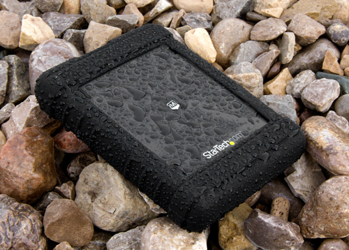 Rugged enclosure sitting outdoors on a rock bed in the rain