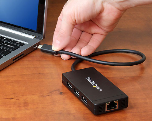 Photo illustrant les ports USB et Gigabit Ethernet du hub ainsi que le hub connect&egrave; au port USB C d'un ordinateur portable 